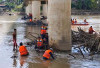 Bersihkan Sampah, Ranting dan Kayu Besar Nyangkut di Kaki Jembatan Lama Muara Rupit 